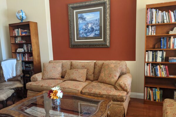 occupied living room home staging in Northern California, with floral sofa set and bookcases